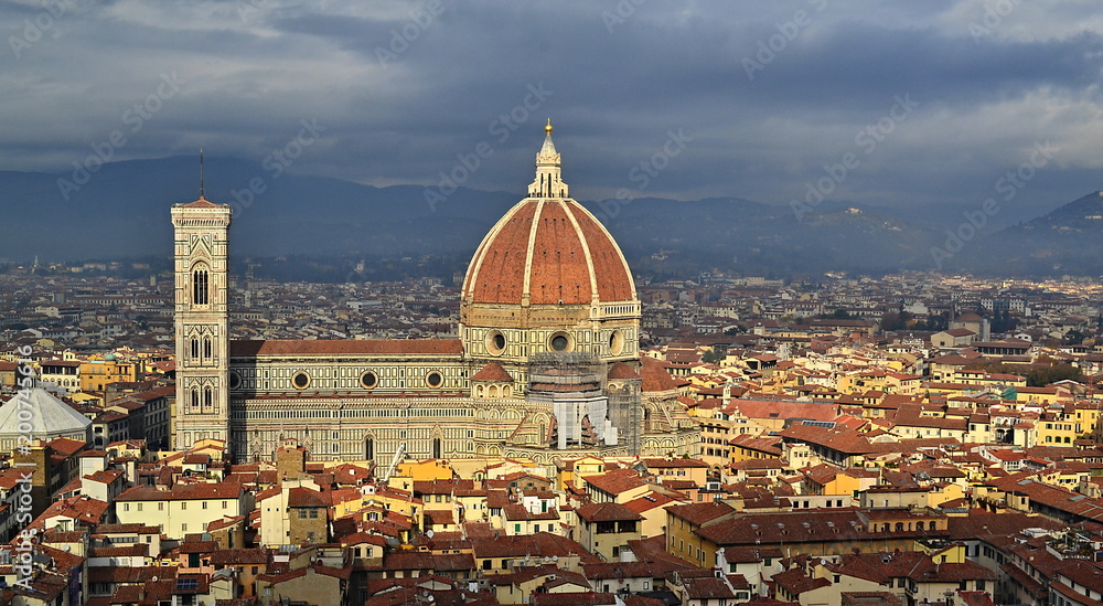 Bright Maria del Fiore cathedral illuminated by sun rays between clouds