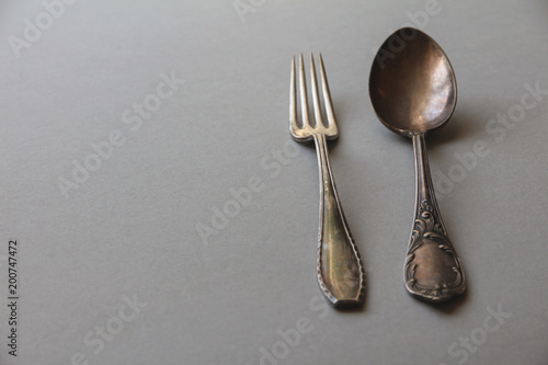 old silver spoon and fork on a gray background