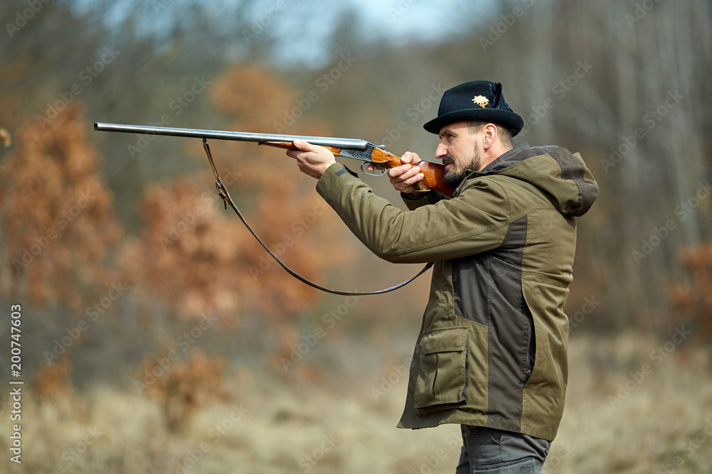 Fototapeta premium Hunter with gun in the forest