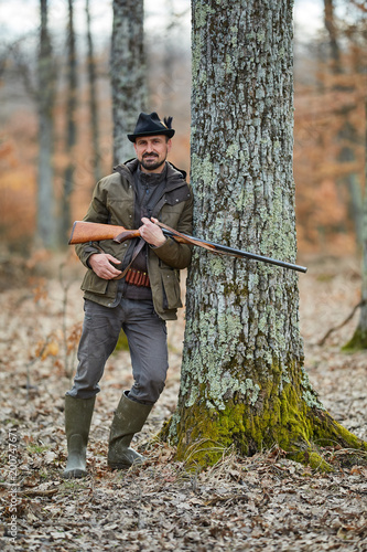 Hunter with gun in the forest