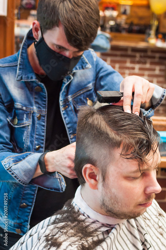 master hairdresser cuts a man in the salon