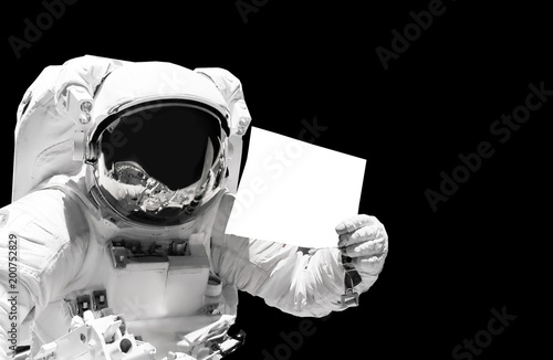 Astronaut close up holding a blank sheet of paper. Spaceman in outer space. Elements of this image furnished by NASA