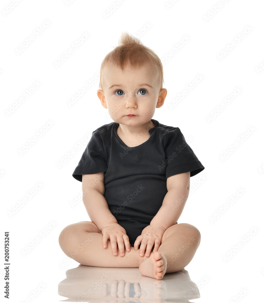 9 month infant child baby girl toddler sitting in dark grey shirt looking up isolated on a white 9 month infant child baby girl toddler sitting in dark grey shirt looking up isolated on a white