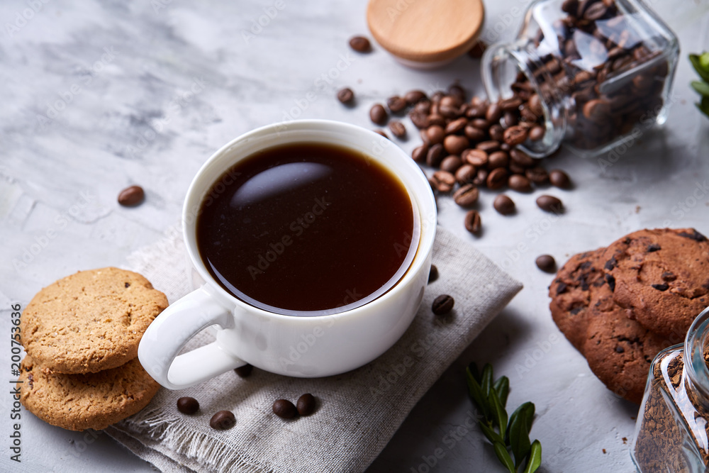 Morning coffee in white cup, chocolate chips cookies on homespun napkin, close-up, selective focus Morning coffee in white cup, chocolate chips cookies on homespun napkin, close-up, selective focus