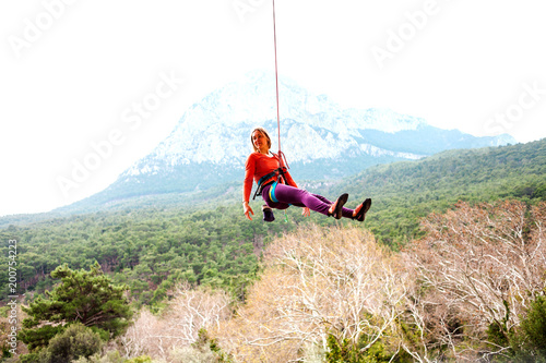 A woman is hanging on a rope.