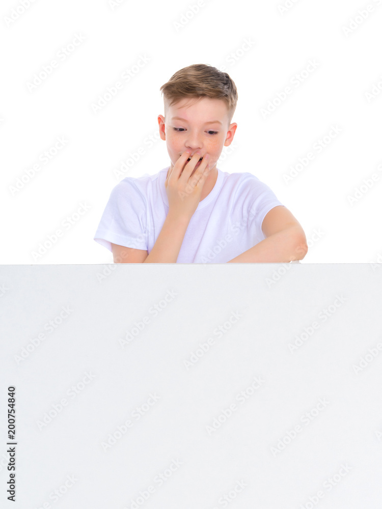 A boy of school age near a white advertising banner. A boy of school age near a white advertising banner.