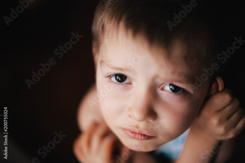 Kids emotion. Little boy with fear afraid expression. Close up portrait isolated on black background