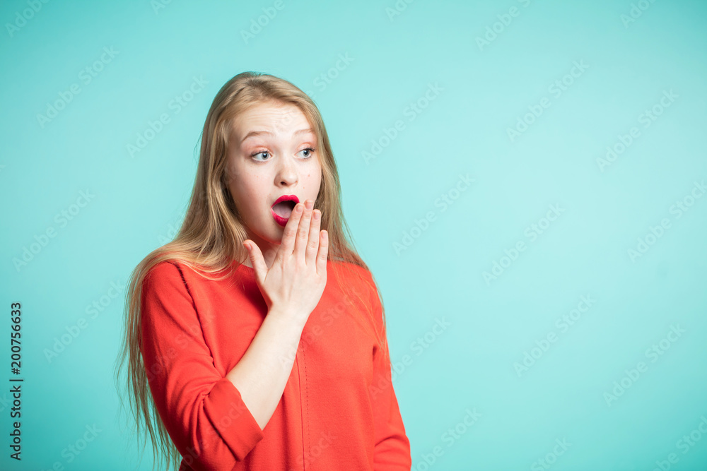 Excited girl in red dress shouting and looking away. Surprised woman on blue background Excited girl in red dress shouting and looking away. Surprised woman on blue background