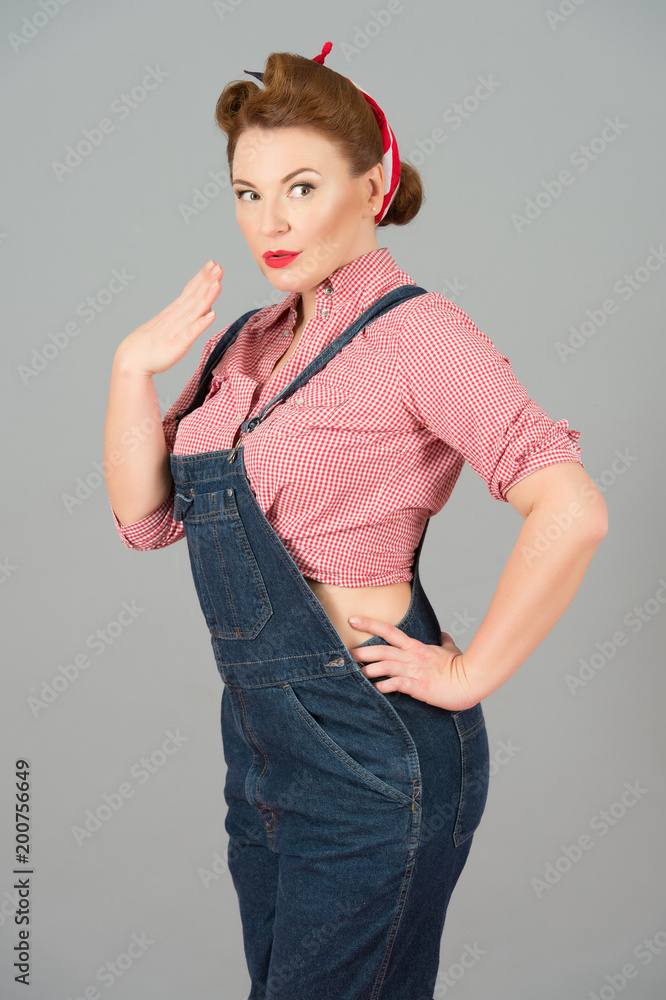 brunette pin up styled girl in denim isolated in studio on gray background.  attractive pin-up woman playing with hand. portrait of sexy beautiful woman  in denim Stock Photo | Adobe Stock