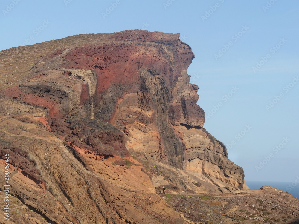 Madeira, Portugalia - niesamowite kolory skał na półwyspie Ponta de Sao Lourenco i turysta idący ścieżką