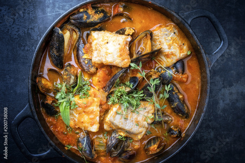 Traditional French Corsican fish stew with mussels as top view in a pot with copy space