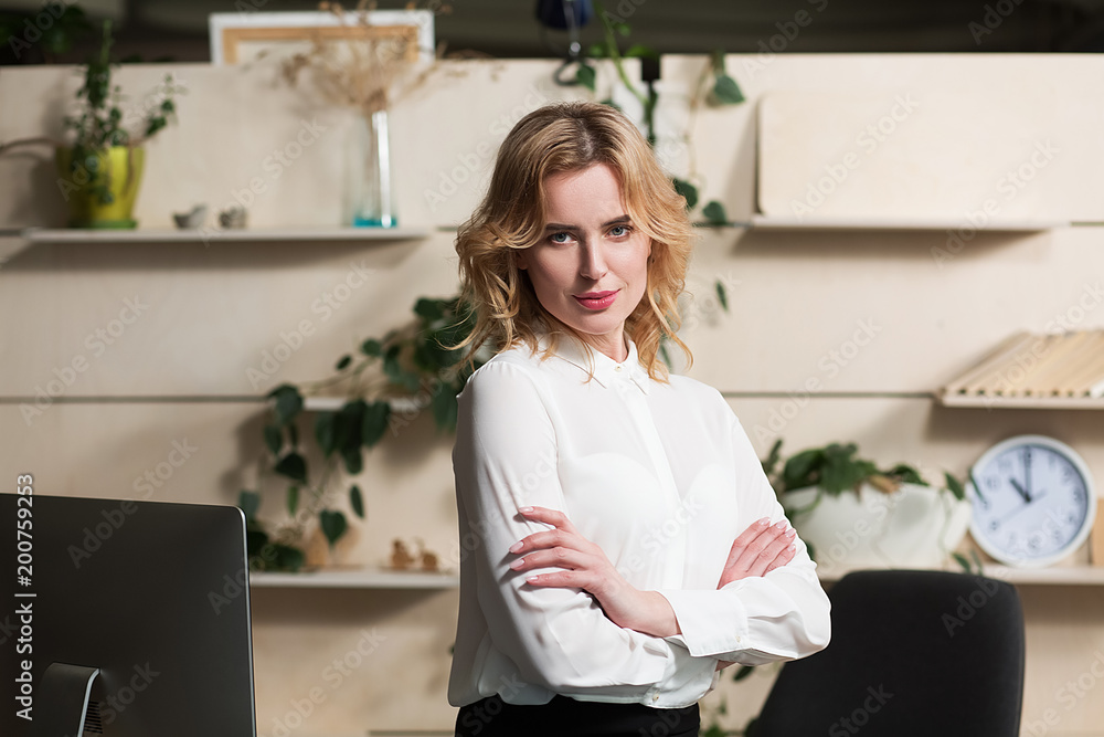 Beautiful businesslady posing on camera in modern office. Crossing hands. Beautiful businesslady posing on camera in modern office. Crossing hands.