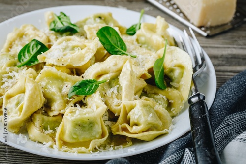 Italian ravioli pasta with spinach and ricotta on wooden background