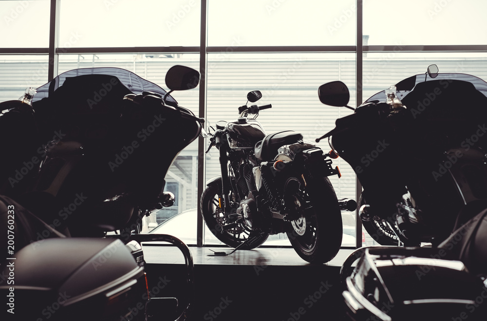 Fototapeta premium image of a new motorcycle in the store. Motorcycles and accessories in a modern motorcycle store. cool motorcycle in the motor cabin silhouette. The concept of motorcycles