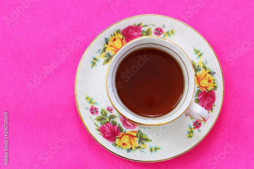 Cup of black tea on vivid pink background with copy space  