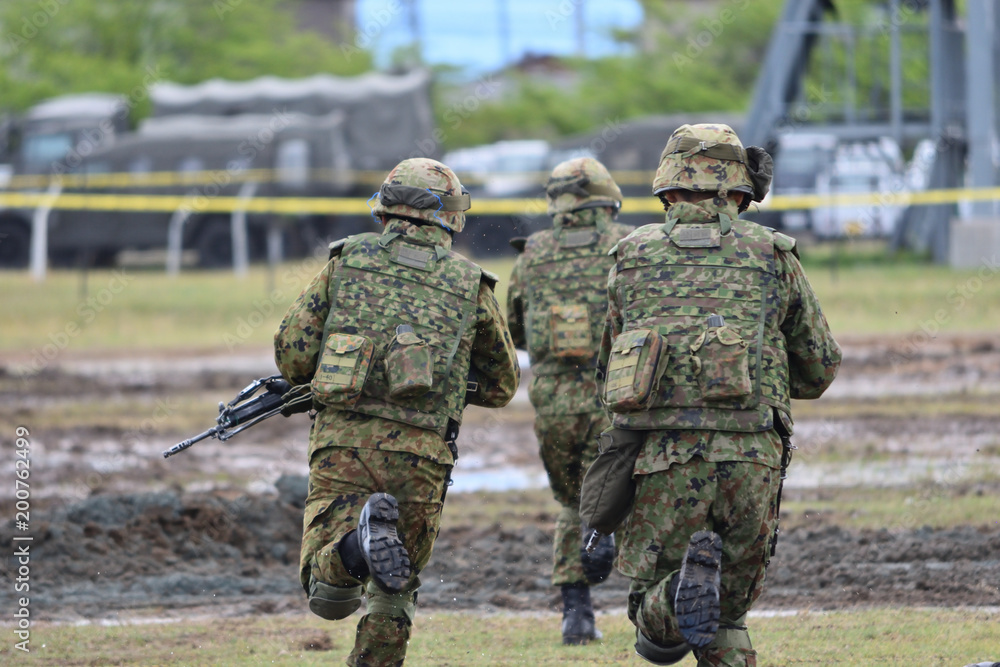 走る武装した自衛官の後姿 走る武装した自衛官の後姿