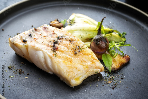 Wall Mural Modern Thai fried cod fish filet with bok choi and mushrooms as close up on a pl