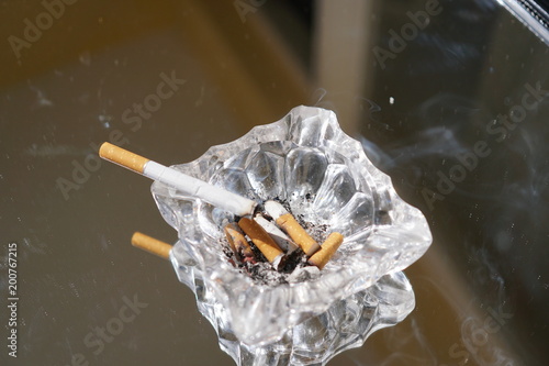 Canvastavla Ashtray with burning cigarette and other butts
