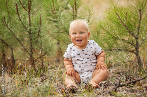 Portrait of a baby boy in green pine forest