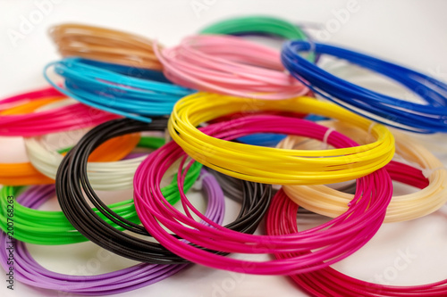 Group of colourful  ABS and PLA plastic filament for 3D printer and pen on white background photo