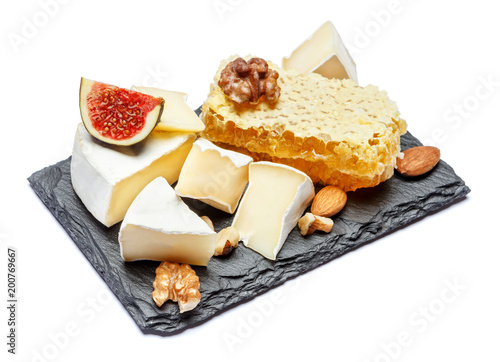 Camembert cheese with honey, figs, walnuts on stone board
