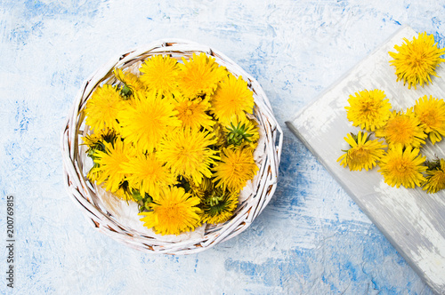 Fototapeta Naklejka Na Ścianę i Meble -  Dandelion flowers in wicker bowl top view