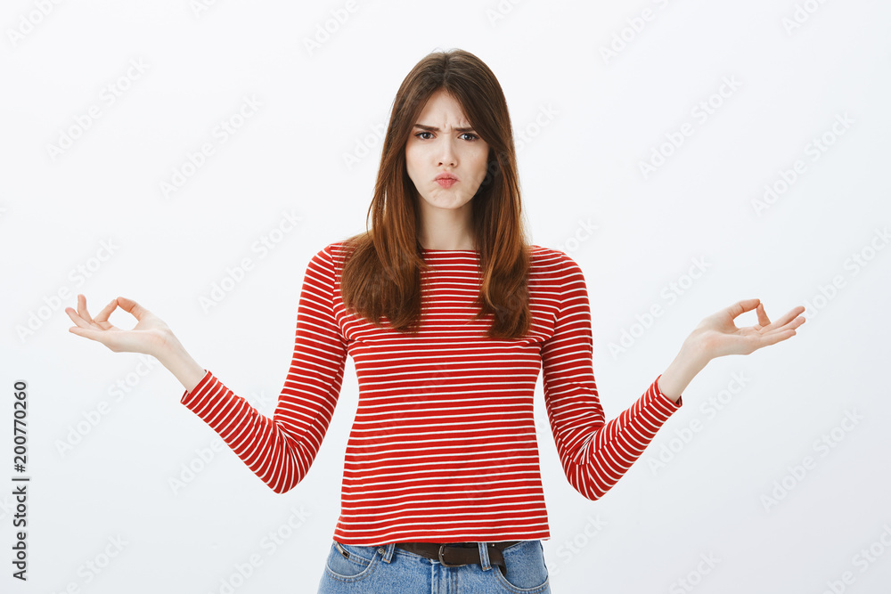 Girl cannot concentrate, feeling annoyed from noisy coworker. Displeased mature european woman meditating with spread arms and zen gesture, frowning and sulking, being interrupted during yoga lesson Girl cannot concentrate, feeling annoyed from noisy coworker. Displeased mature european woman meditating with spread arms and zen gesture, frowning and sulking, being interrupted during yoga lesson