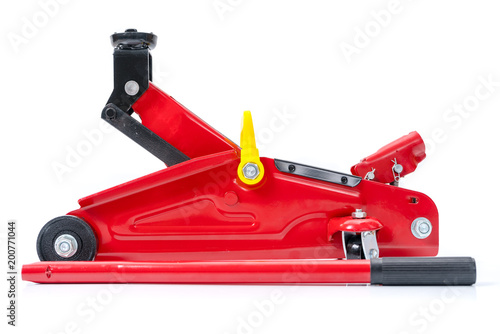Red hydraulic floor jack isolated on white background.