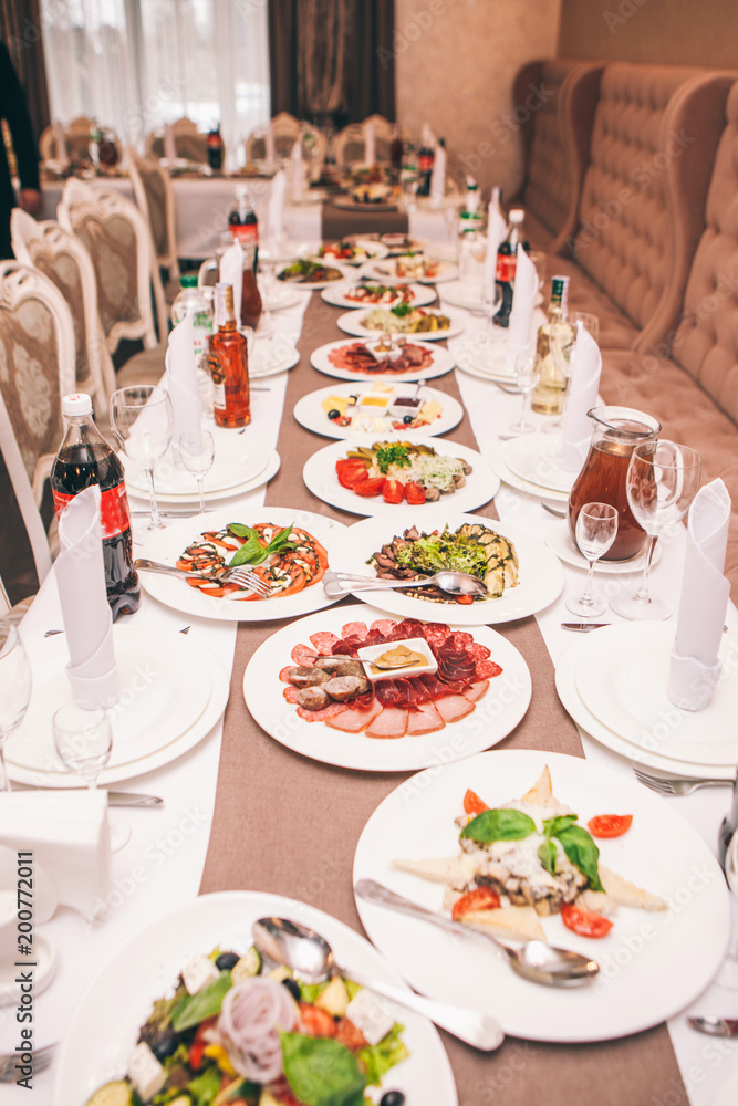 hall with a celebration table and with snacks, dishes and drinks for guests hall with a celebration table and with snacks, dishes and drinks for guests