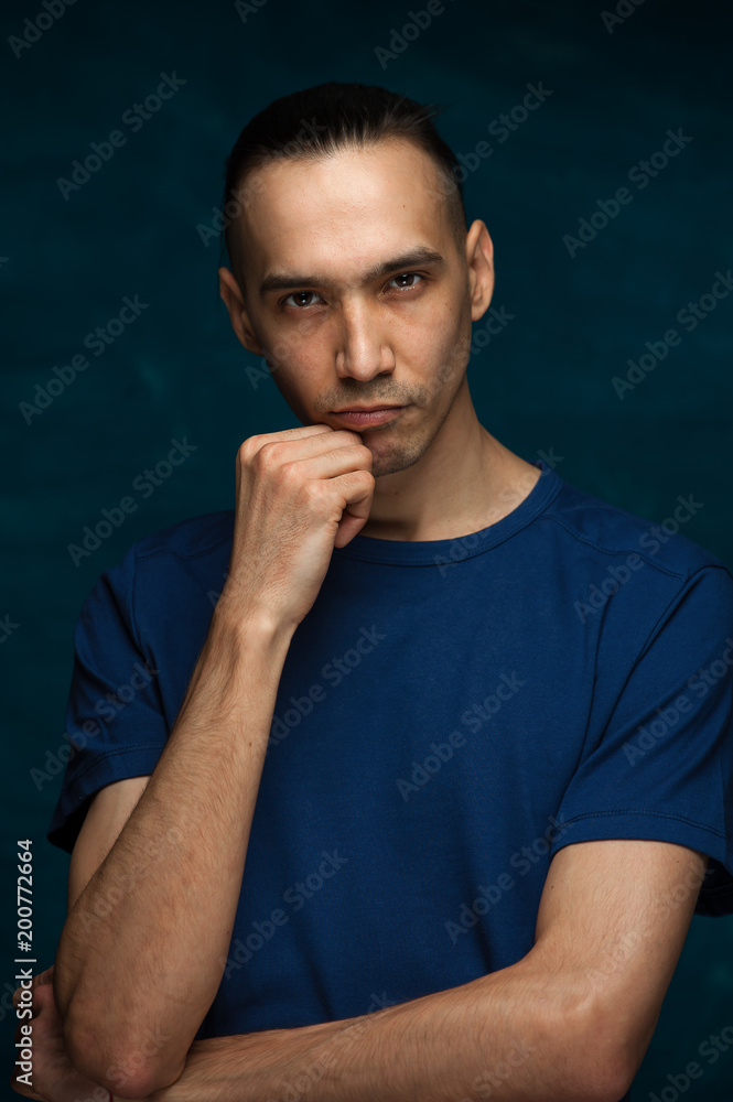 Portrait of young stylish hipster guy looking at the camera on blue background Portrait of young stylish hipster guy looking at the camera on blue background
