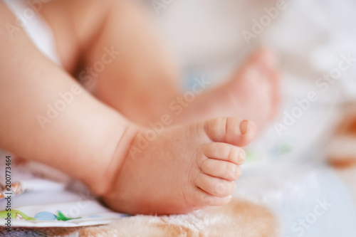 small baby legs lays on the bed © Porokhniak Valentyn
