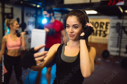 Young girl is taking selfie during workout in gym