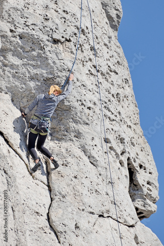 A woman climbing the rocks.