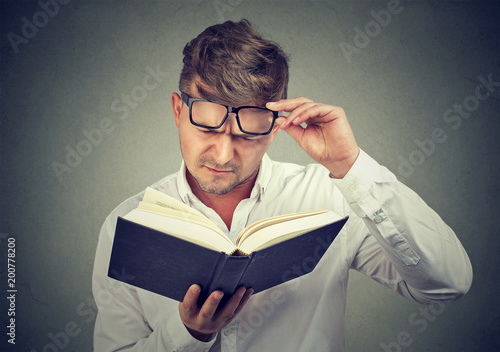 Stampa su tela Frowning man having problems with reading