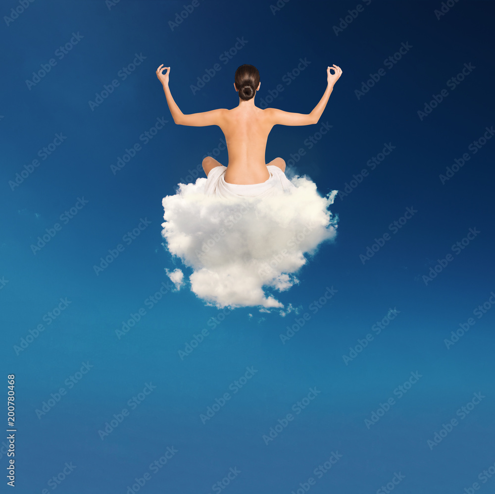 Young girl practices yoga over a cloud