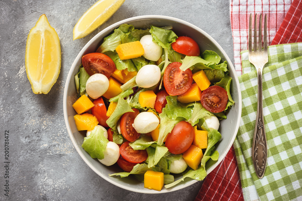 Salad with mango, tomatoes, mozzarella and lemon. Salad with mango, tomatoes, mozzarella and lemon.