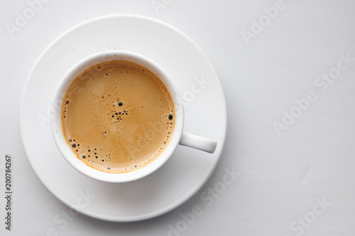 Coffee cup on saucer on white background. Top view with copyspace for your text