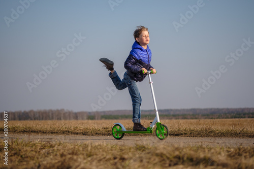 Tableau sur toile European boy riding and doing stunts on scooter