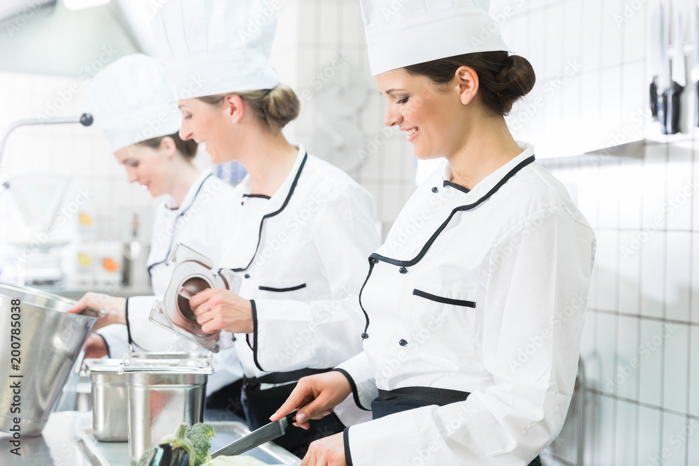 Team of chefs preparing food in canteen kitchen Team of chefs preparing food in canteen kitchen