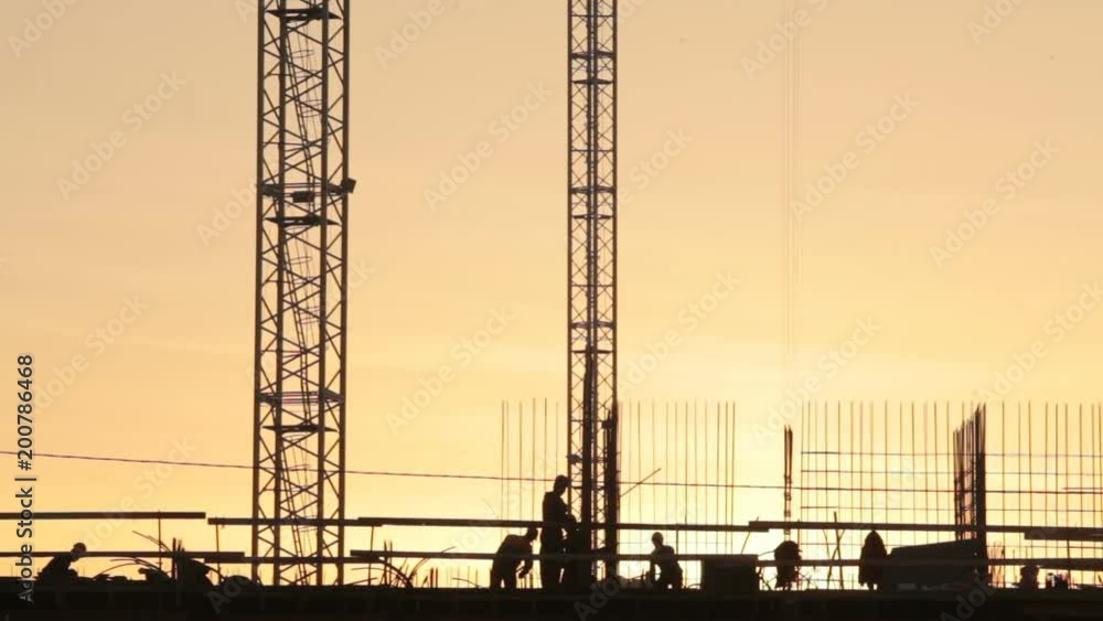 the Builder carries the construction of the I-beam at sunset the Builder carries the construction of the I-beam at sunset