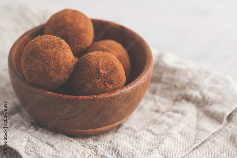 Homemade Healthy vegan Raw Energy truffle Balls with carob in wooden bowl. Healthy vegan food concept.