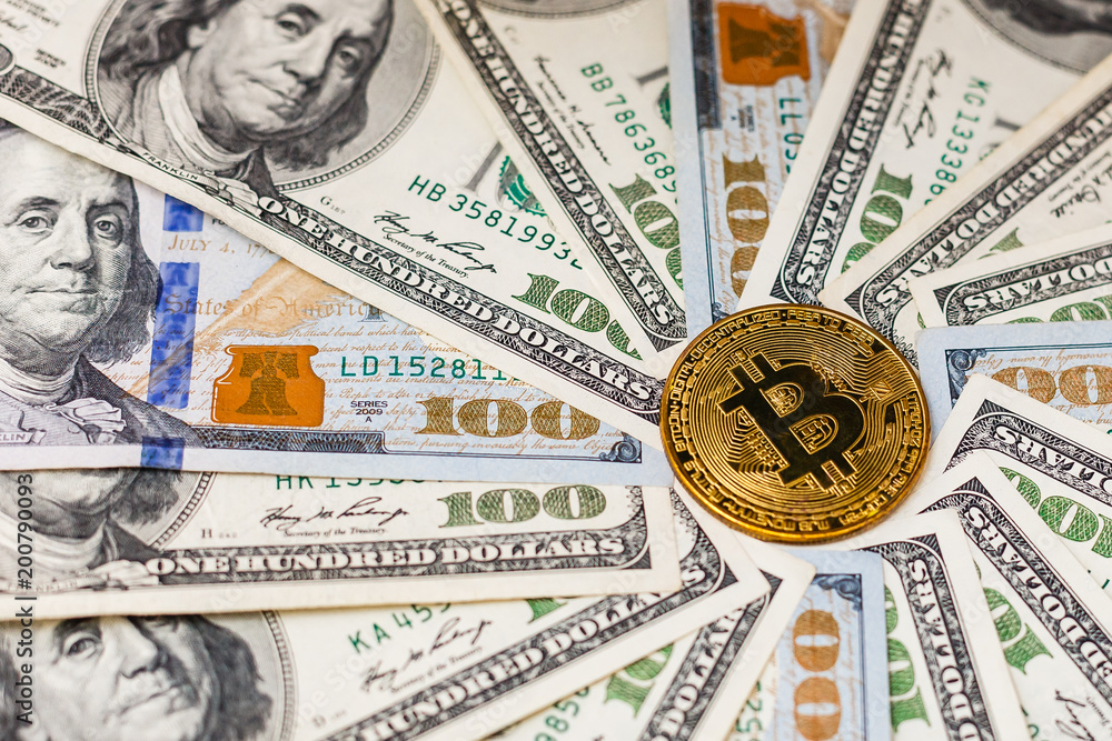 One bitcoin on hundred dollars bills closeup macro shot One bitcoin on hundred dollars bills closeup macro shot