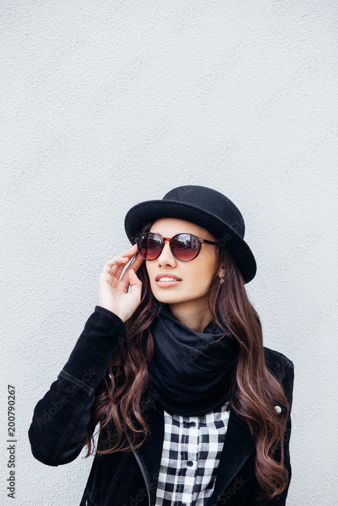 Smiling urban girl with smile on her face. Portrait of fashionable gir wearing a rock black style having fun outdoors Smiling urban girl with smile on her face. Portrait of fashionable gir wearing a rock black style having fun outdoors