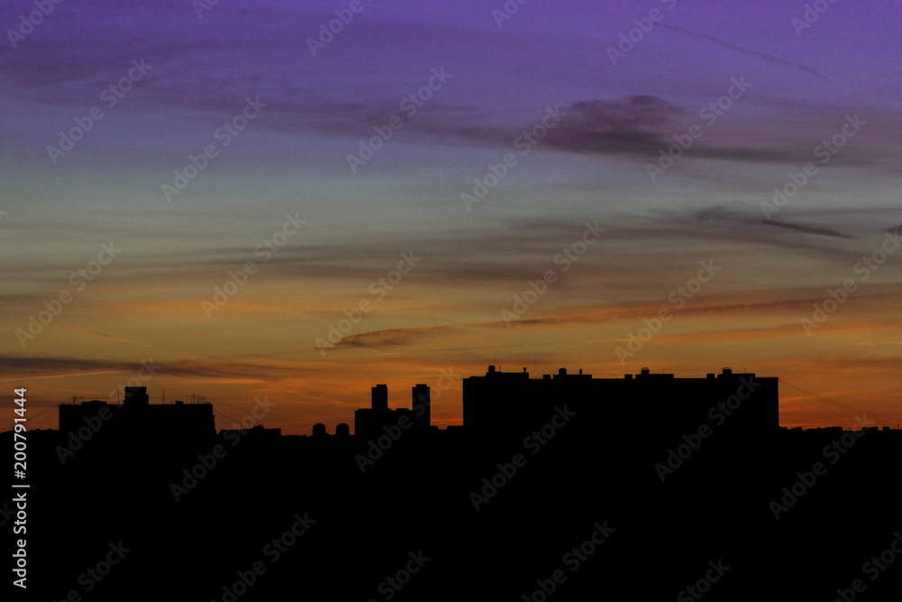 Silhouettes of houses against the backdrop of a delightful sunset in the city