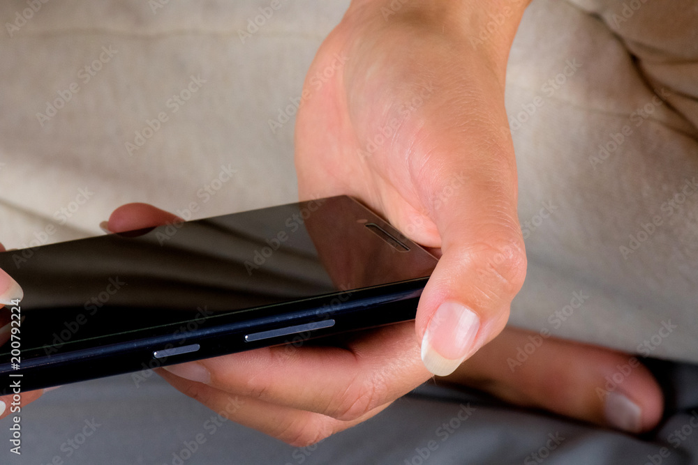 Woman sitting on bed and writing message on cellphone. Woman sitting on bed and writing message on cellphone.