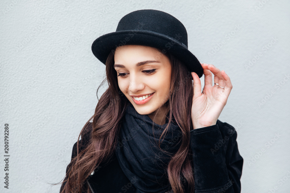 Smiling urban girl with smile on her face. Portrait of fashionable gir wearing a rock black style having fun outdoors Smiling urban girl with smile on her face. Portrait of fashionable gir wearing a rock black style having fun outdoors