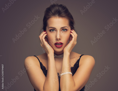 Beautiful model girl with elegant hairstyle . Woman with red lips and nails . Cosmetics, beauty and manicure on nails.