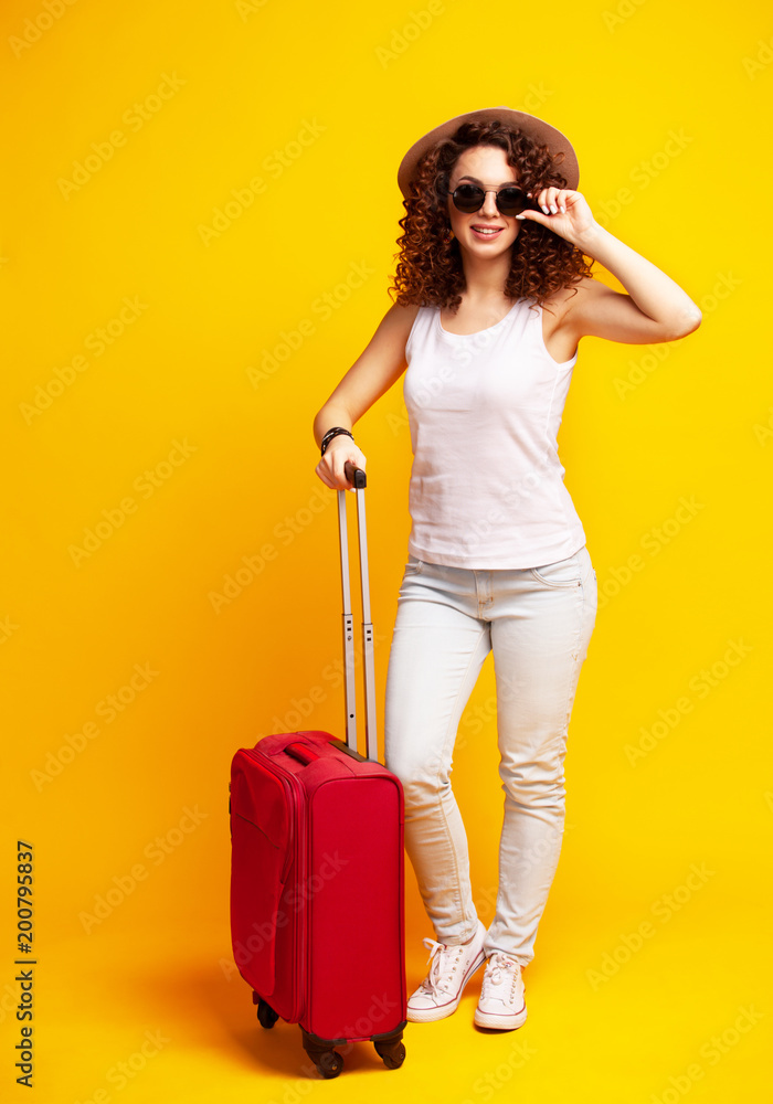 Woman traveler with suitcase on color background. Woman traveler with suitcase on color background.