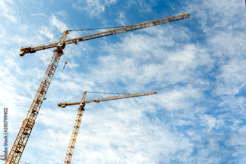 Two high tower cranes work on construction of new homes