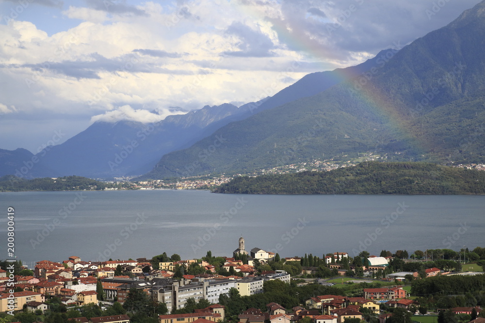 Blick über Gravedona nach Colico am Comer See mit einem bunten Regenbogen im Sonnenschein